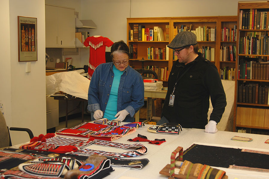A woman and man inspecting Native American artwork.